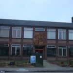 De hoofdingang met relief erboven vlak voor de afbraak