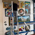 De technische dienst hangt het schilderij op